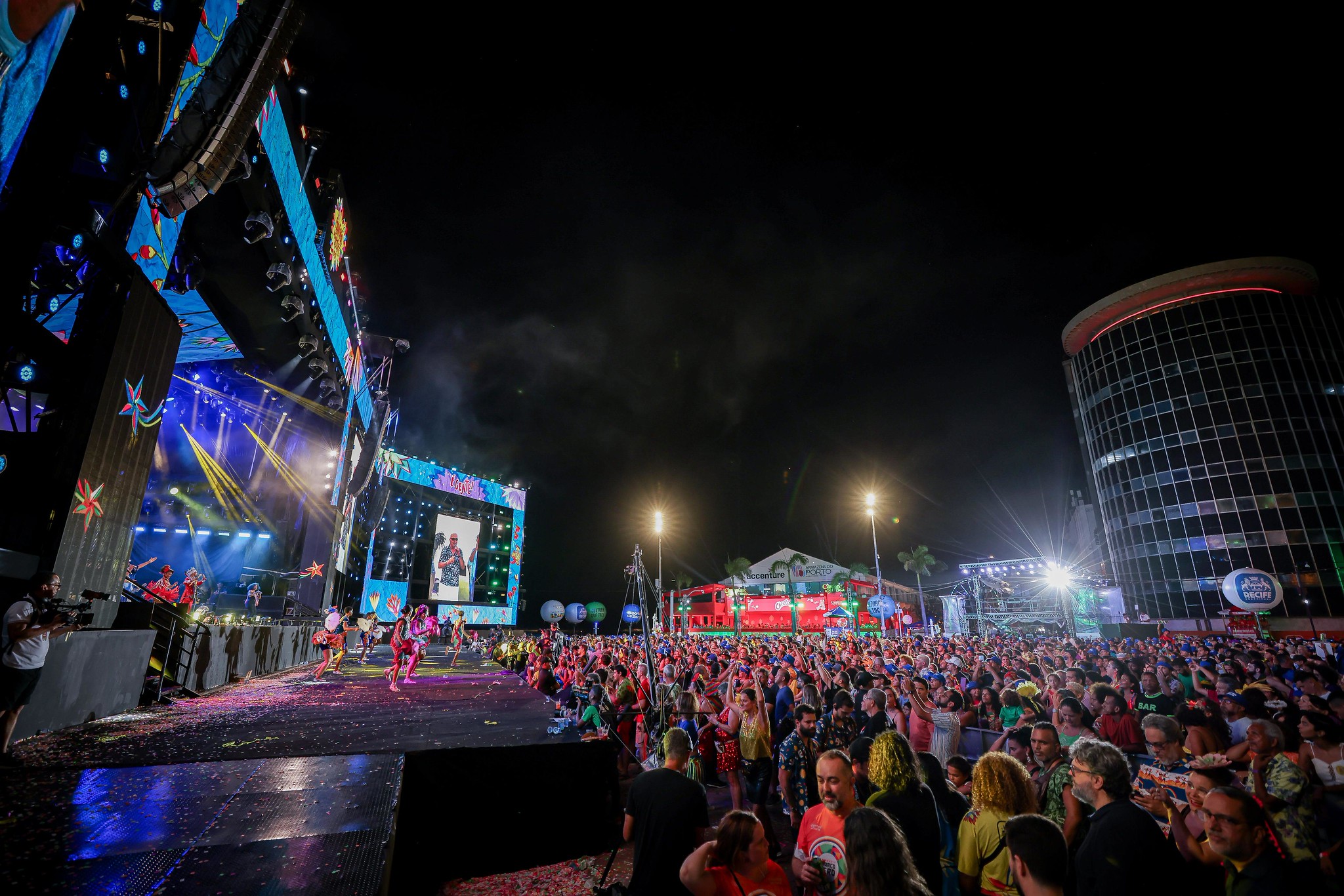 Público em frente ao palco iluminado do Marco Zero durante show noturno no Carnaval do Recife 2026.