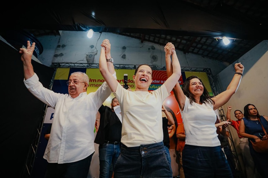 O prefeito de Gravatá, Joselito Gomes, e a primeira-dama Viviane Facundes aparecem em palco ao lado da governadora de Pernambuco e presidente estadual do PSD, Raquel Lyra, durante ato político de filiação partidária.