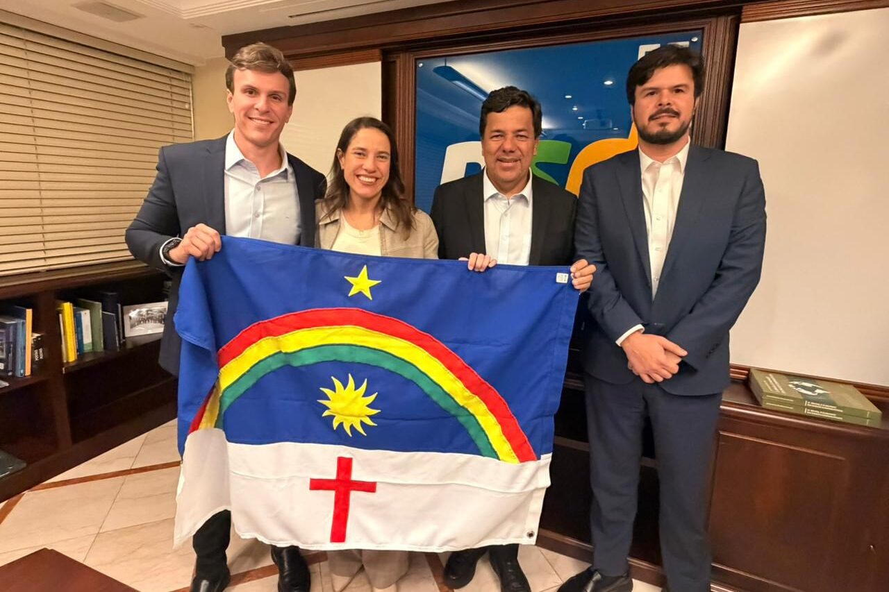 Miguel Coelho, Raquel Lyra, Mendonça Filho e Fernando Filho posam com a bandeira de Pernambuco em reunião política.