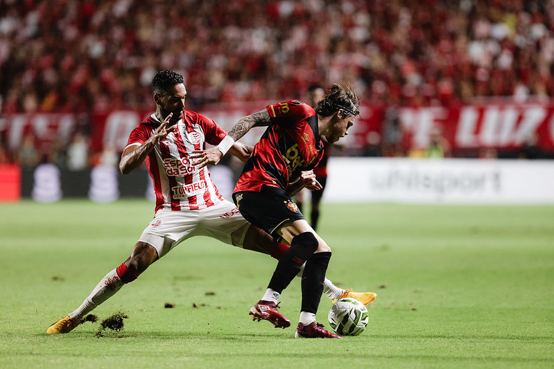 Jogadores de Sport e Náutico disputam a bola em partida de futebol.