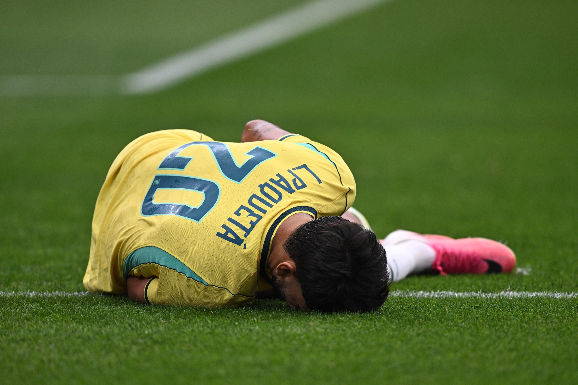 Lucas Paquetá caído no gramado após lesão muscular contra o Japão.